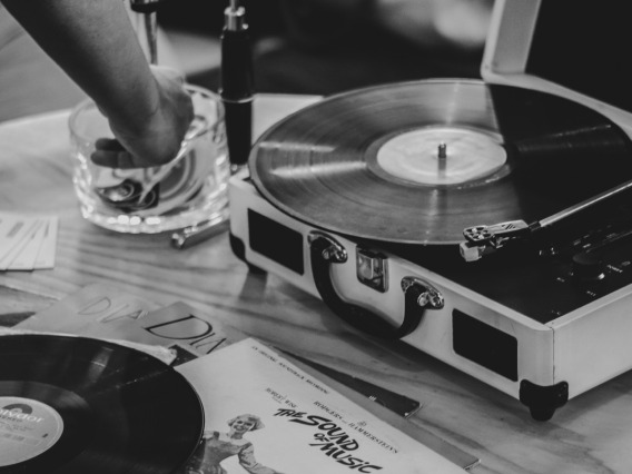Grayscale image of a record player and a record atop a table