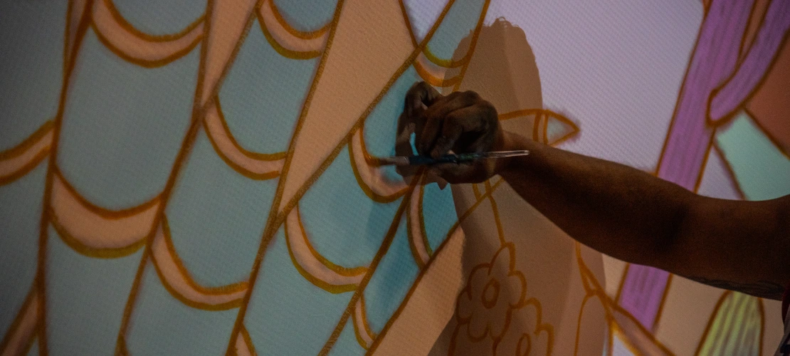 Close shot of an artist working on their mural
