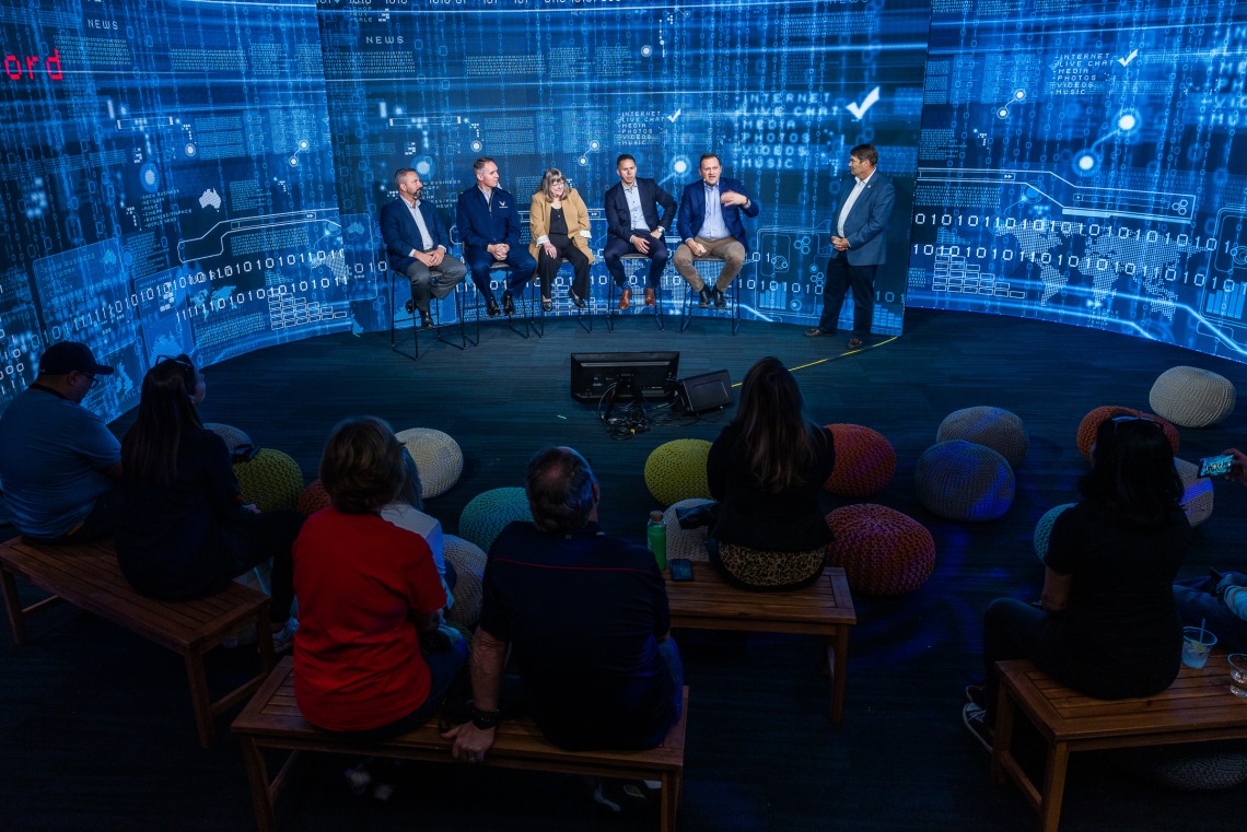 Cyber panel talking in front of a digital background