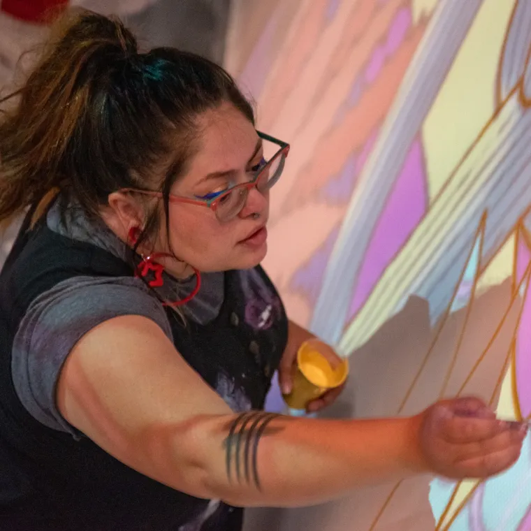 Jessica Gonzales painting the undercoating for mural, "Dandelion"