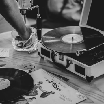 Grayscale image of a record player and a record atop a table