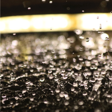 Close up photo of water droplets against dancing in the air